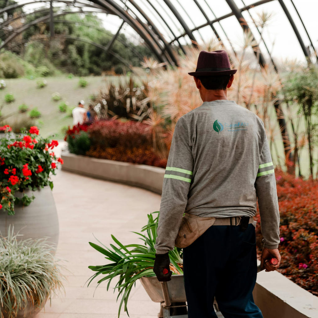 A man holding green plant and walking around in a garden .
